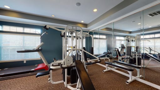 a gym with weights and cardio equipment at the enclave at university heights