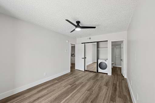 A room with a ceiling fan and a washer and dryer in it.