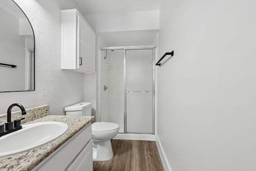 A bathroom with a sink, toilet, and shower.