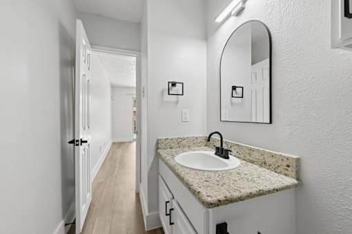 A bathroom with a sink and mirror.