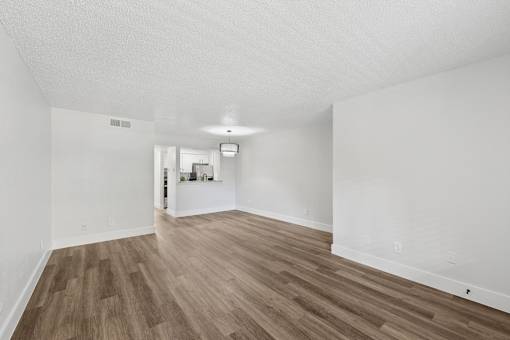 A room with wooden flooring and white walls.