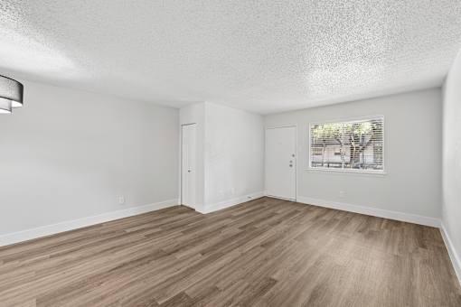 A room with wooden flooring and white walls.