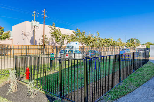 A black metal fence surrounds a green lawn.