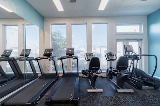 A gym with treadmills and elliptical machines.