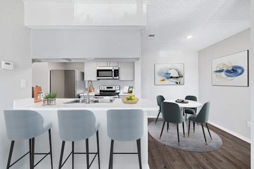 A modern kitchen with a dining table and chairs.