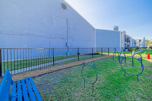 A white building with a blue bench in front of it.