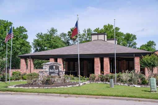 the front of a brick building with two flags in front of it