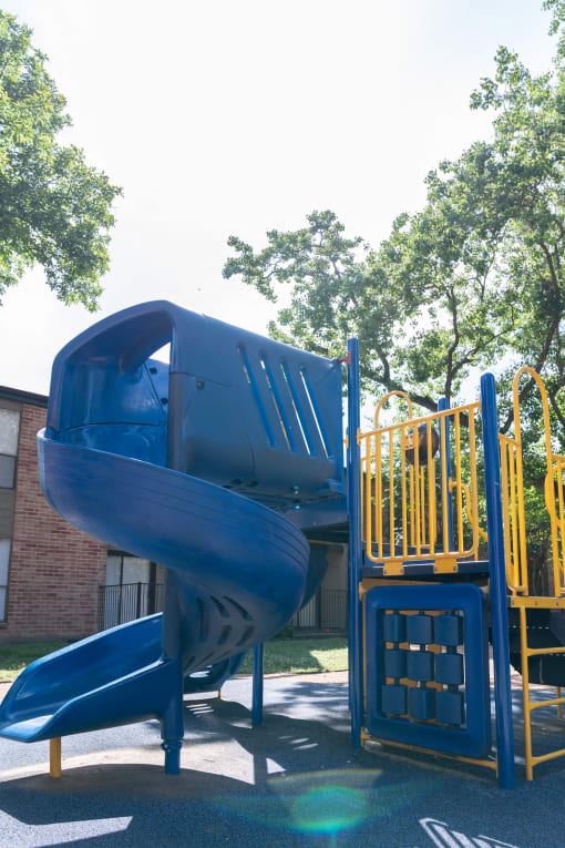 a playground with a blue slide and a yellow slide