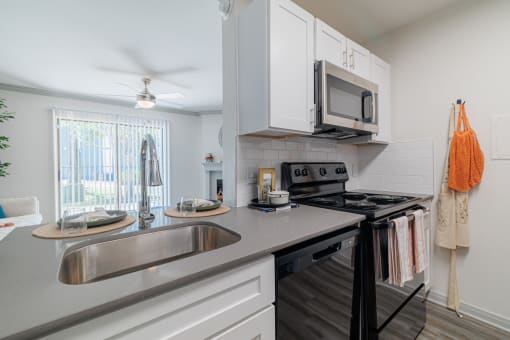 a kitchen with a sink and a stove and a microwave
