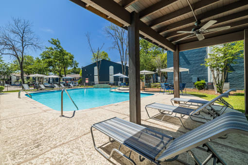 our resort style swimming pool is under a covered patio with lounge chairs