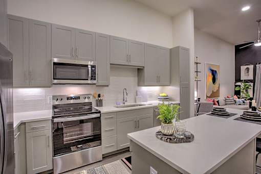 A modern kitchen with a stainless steel refrigerator and oven.