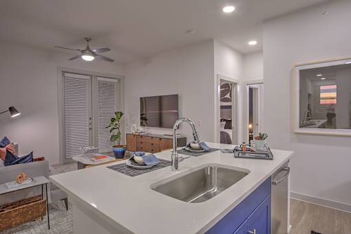 A modern kitchen with a white countertop and blue cabinets.