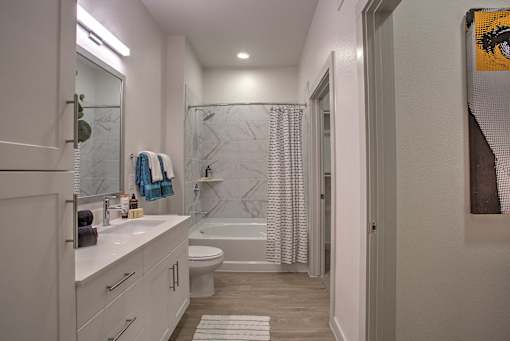 A bathroom with a white counter and a white toilet.