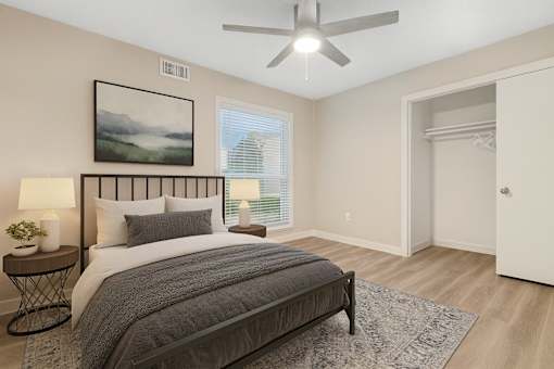 A bedroom with a large bed and a ceiling fan.