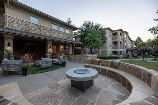 Stone patio with a firepit at Woodbridge Villas Apartments, Sachse