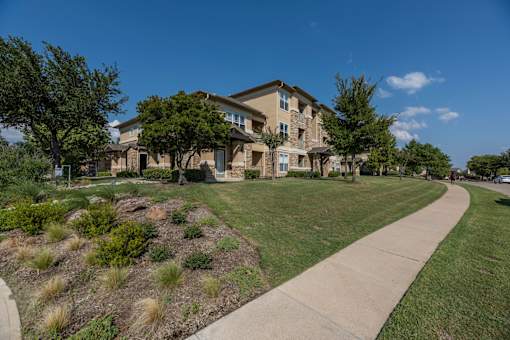 Apartment complex with a walkway at Woodbridge Villas Apartments, Sachse, TX, 75048