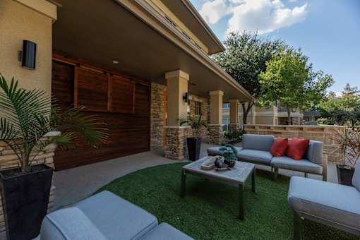 Patio with a grey couch at Woodbridge Villas Apartments, Sachse, TX, 75048