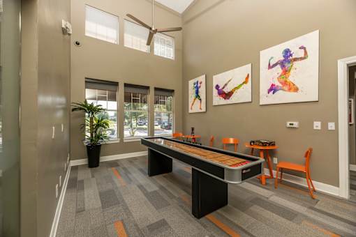 Clubhouse with fitness-themed wall art at Woodbridge Villas Apartments, Texas