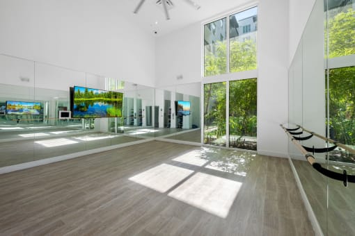 a large white room with large windows and a tv on the wall