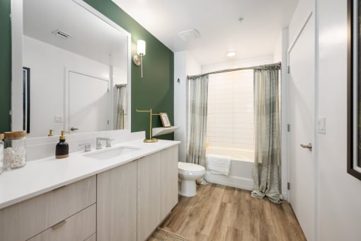 a bathroom with a white sink and a toilet and a shower