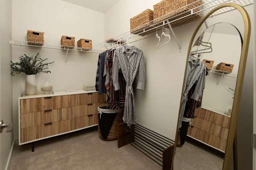 A room with a white wall and a wooden cabinet with drawers.