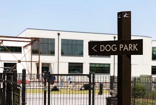A sign pointing to the left for the dog park.