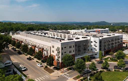 A large white building with a parking lot in front of it.