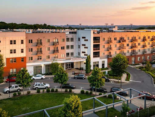 A parking lot is in front of a white and orange building.