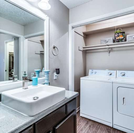 A bathroom with a white sink and a white washing machine.