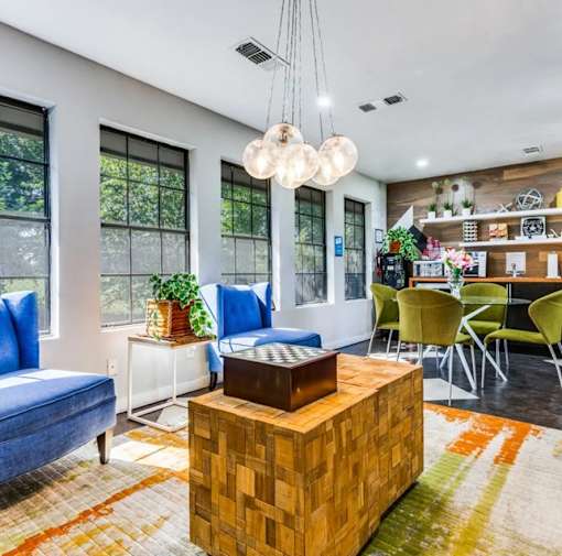 A living room with a blue couch, a wooden coffee table, and a rug with a geometric pattern.