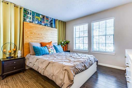 A bedroom with a bed, nightstand, and window.