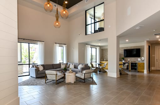A spacious living room with a grey sofa set and a television.