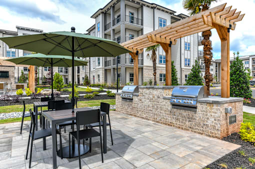A patio with a table and chairs under a green umbrella.