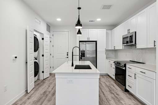 A modern kitchen with white cabinets and a central island.