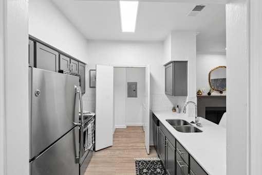 A modern kitchen with a stainless steel refrigerator and a sink.