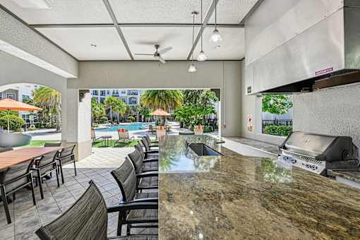 A kitchen area with a marble countertop and a grill.
