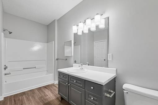 A bathroom with a white sink and a white bathtub.