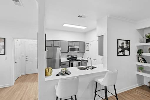 A modern kitchen with a white countertop and a sink.