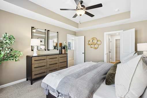 A bedroom with a large bed and a ceiling fan.