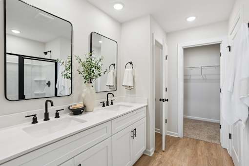 A white bathroom with a large mirror above the sink.