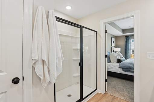 A white towel is hanging on a black door.