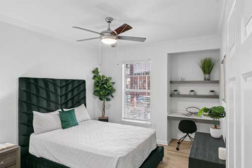 A bedroom with a bed, desk, and chair.