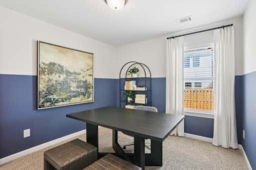 A dining room with a table and chairs.