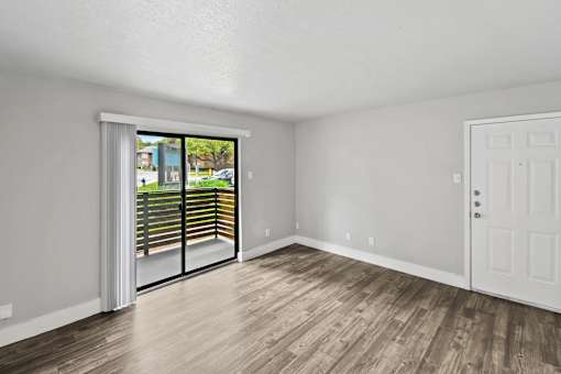 A room with a sliding glass door leading to a balcony.