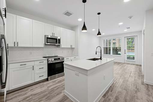 A modern kitchen with white cabinets and a large island.