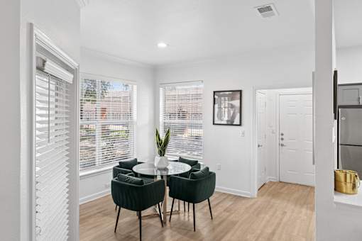 A dining room with a table and chairs.