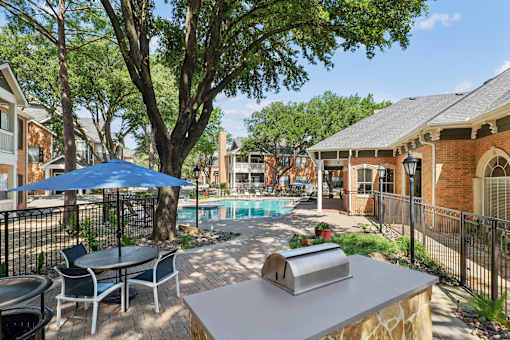 A backyard with a pool and a table with chairs.