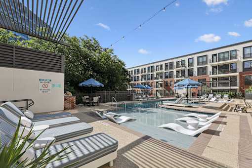 A pool area with sun loungers and a sign that says 'No Diving'.