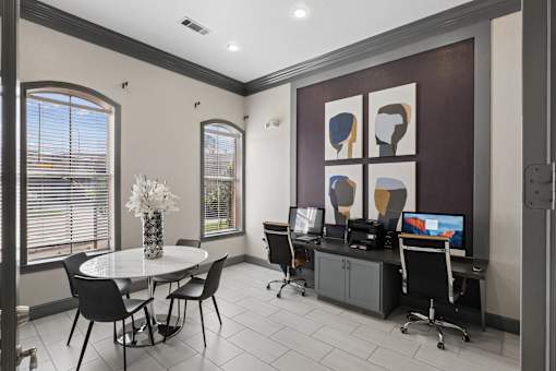 A room with a table, chairs, and a computer.