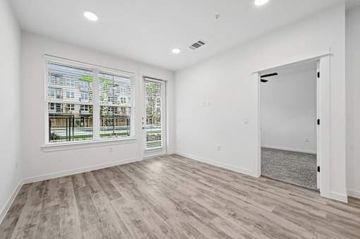 A room with a large window and a view of a building across the street.